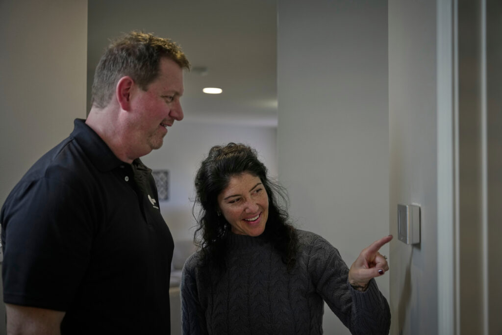trane dealer and woman at smart thermostat